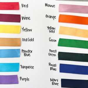 May include: A color chart of 5/8 inch satin ribbon samples. Colors include white, red, wine, yellow, old gold, powder blue, turquoise, purple, brown, silver, mauve, orange, yellow gold, green, forest green, royal blue, navy blue, and black.