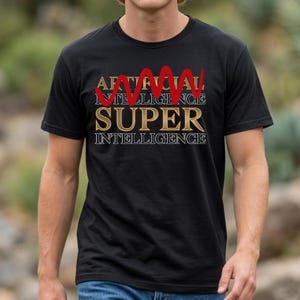 May include: A black short-sleeved t-shirt featuring the text ARTIFICIAL INTELLIGENCE in gold, a red wavy line across the top, and the word SUPER in large gold letters, followed by the word INTELLIGENCE in white outlined text on the chest.
