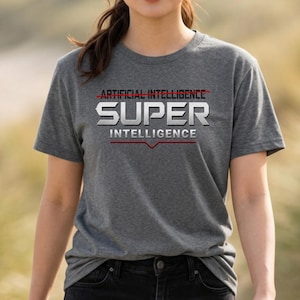 May include: A heather grey short-sleeve t-shirt featuring the text ARTIFICIAL INTELLIGENCE with a red line through it, followed by the word SUPER in large metallic silver letters, and the word INTELLIGENCE below with a red line underneath.