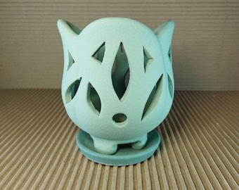 Small ceramic pot for orchids with light holes, on legs. Covered in teal (blue-green). Completely unglazed. Set of two pot and saucer.