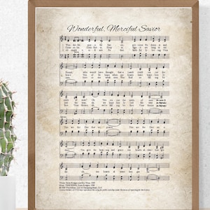 May include: A framed print featuring sheet music with the title "Wonderful, Merciful Savior" in elegant script. The background has a vintage, aged paper appearance. The print is in a wooden frame, adding a classic touch to the artwork.