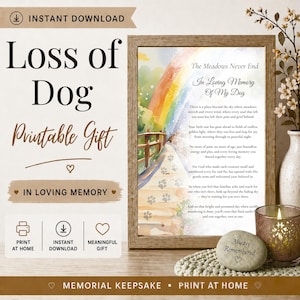 Op de afbeelding: Een ingelijste print met de tekst "Loss of Dog" en "In Loving Memory". Het kunstwerk toont een regenboog over een pad met pootafdrukken en een gedicht. Een kaars en een steen met "Always Remembered" staan ook in de afbeelding.