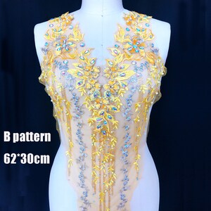以下が含まれることがあります： 花柄のビーズと刺繍が施された黄色のアップリケ。アップリケは62インチ×30インチで、透き通った生地に施されています。