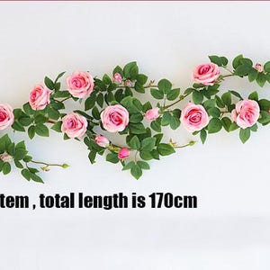May include: A single stem of artificial roses with pink blossoms and green leaves. The total length of the stem is 170cm.