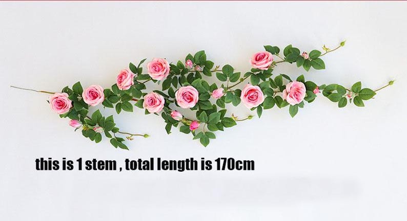 May include: A single stem of artificial roses with pink blossoms and green leaves. The total length of the stem is 170cm.