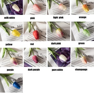 Op de afbeelding: Een set van 11 kunstmatige tulpenstengels in verschillende kleuren, waaronder melkachtig wit, roze, lichtroze, oranje, geel, rood, donkerroze, groen, paars, donkerpaars en blauw. De tulpen zijn gerangschikt in een raster op een witte achtergrond.