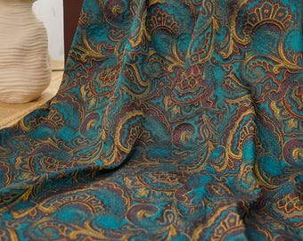 Könnte beinhalten: Tealfarbener Stoff mit Paisley-Muster in Gold und Braun. Der Stoff hat eine strukturierte, fast flauschige Oberfläche.