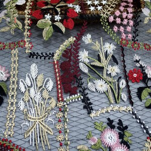 Puede incluir: Tela de malla negra con dise&ntilde;os florales bordados en tonos rojos, verdes, blancos y rosas.