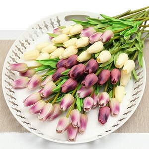 Op de afbeelding: Een boeket kunstmatige tulpen in cr&egrave;me, paars en roze tinten. De tulpen zijn gerangschikt in een wit decoratief dienblad.