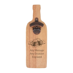 Puede incluir: Abrebotellas de madera con forma de botella de cerveza con un abrebotellas de metal que dice "Cheers" y "Open". El abrebotellas tiene un diseño de dos jarras de cerveza chocando. El texto "Any Message Any Occasion Engraved" también está en el abrebotellas.
