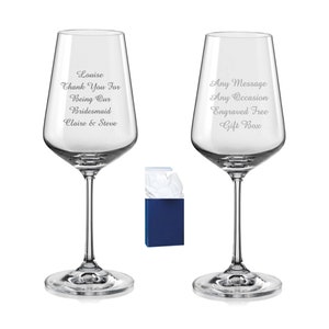 May include: Two clear glass wine glasses with engraved text. The glass on the left says "Louise Thank You For Being Our Bridesmaid Claire & Steve". The glass on the right says "Any Message Any Occasion Engraved Free Gift Box".