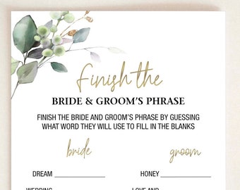 May include: A white card with gold text that reads "Finish the Bride & Groom's Phrase." The card has fill-in-the-blank questions about the bride and groom. Green and gold floral accents are in the upper left corner.