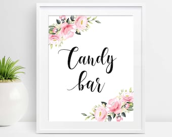 May include: White framed sign with the words "Candy bar" in elegant black script. The sign is decorated with watercolor pink roses and green leaves in the corners, creating a floral border.