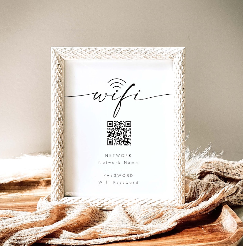 May include: White framed sign with the word "wifi" in cursive script, a black and white QR code, and the text "NETWORK Network Name PASSWORD Wifi Password".