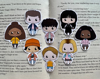 Op de afbeelding: Een verzameling van negen cartoon karakter stickers, elk met een unieke outfit en kapsel. De stickers zijn gerangschikt op een pagina van een boek met gedrukte tekst. De karakters hebben grote ogen en eenvoudige gelaatstrekken.