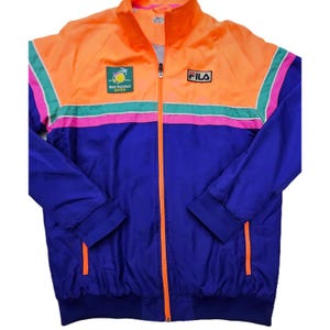 Peut inclure: Veste de surv&ecirc;tement Fila vintage orange, bleue et rose. La veste est dot&eacute;e d'une fermeture &eacute;clair int&eacute;grale, d'un col montant et du logo Fila sur la poitrine. La veste porte l'inscription "BNP PARIBAS OPEN" sur la poitrine.