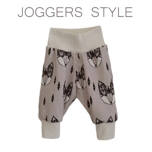 May include: Gray joggers with a geometric fox print and white cuffs. The joggers have the text "JOGGERS STYLE" at the top of the image.