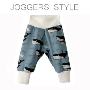 Op de afbeelding: Blauwe joggingbroek met een witte tailleband en witte boorden. De joggingbroek heeft een walvis- en visprint.
