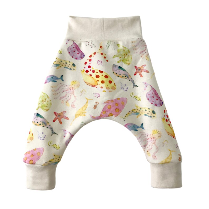 May include: White baby pants with a colorful watercolor print of various sea creatures, including fish, jellyfish, and starfish.