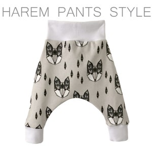 May include: Gray harem pants with a white geometric fox print. The pants have a white waistband and white cuffs.