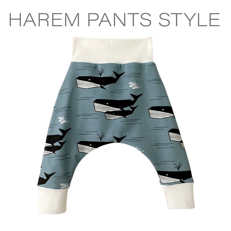 Op de afbeelding: Blauwe harem broek met een witte walvis en vis print. De broek heeft een witte elastische tailleband en manchetten.