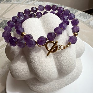 May include: A double-strand necklace made with faceted amethyst beads and a gold-tone toggle clasp.