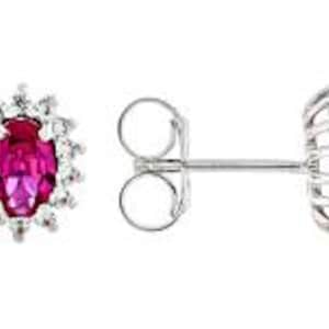 Op de afbeelding: Een paar oorbellen van sterling zilver met een rode ovale robijn-edelsteen omringd door een halo van kleinere witte diamanten.