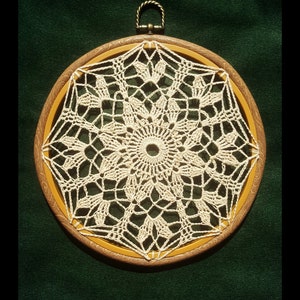 May include: A white crocheted mandala design in a wooden hoop with a brass ring at the top.