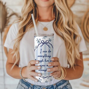 May include: A white and blue stainless steel tumbler with a floral pattern and the quote "I can do everything through him who gives me strength. Philippians 4:13".