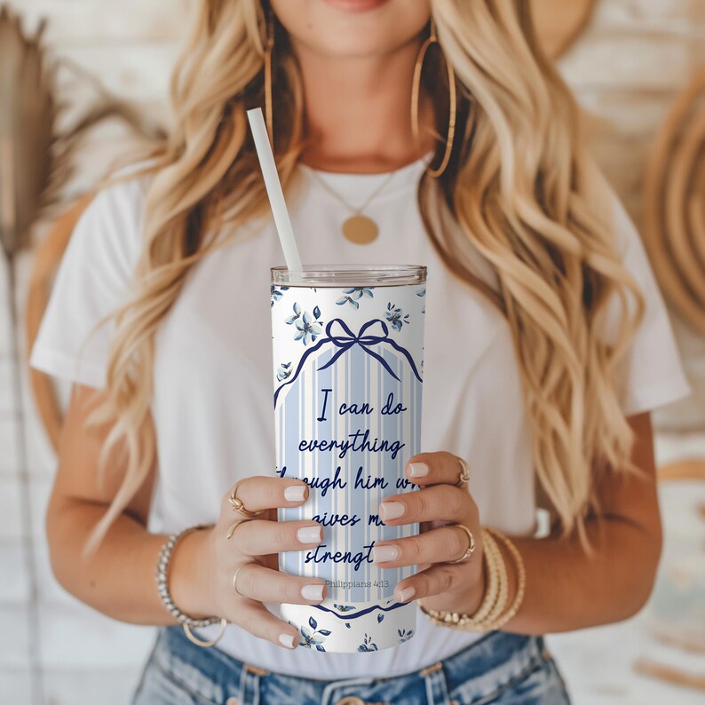 May include: A white and blue stainless steel tumbler with a floral pattern and the quote "I can do everything through him who gives me strength. Philippians 4:13".