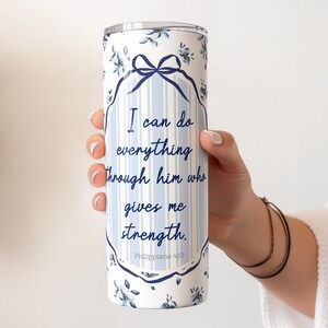 May include: A white stainless steel tumbler with a blue and white floral pattern. The tumbler has a quote that reads "I can do everything through him who gives me strength. Philippians 4:13".