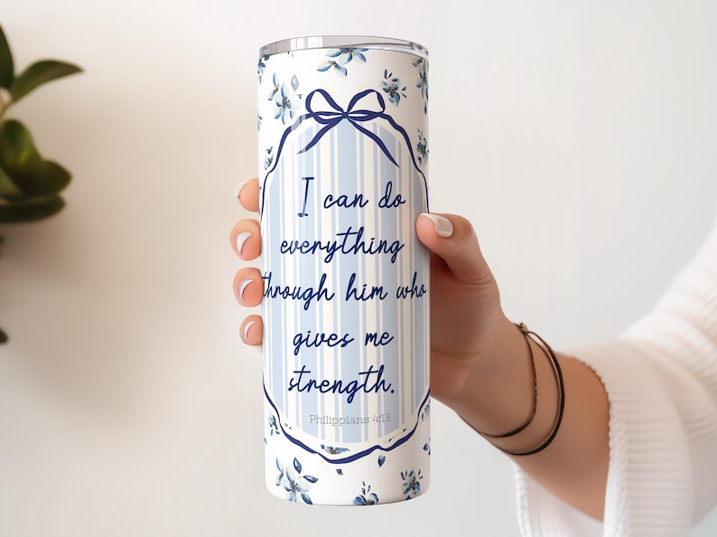 May include: A white stainless steel tumbler with a blue and white floral pattern. The tumbler has a quote that reads "I can do everything through him who gives me strength. Philippians 4:13".