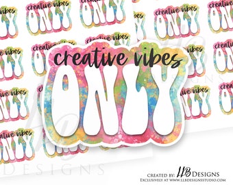 May include: A set of colorful stickers with the text "creative vibes only" in a white, bubbly font. The stickers have a watercolor-like background with pink, blue, yellow, and green colors.