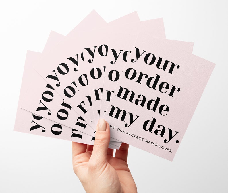 May include: Pink cards with the text "yoyoyoyoyour 0'000 order yoyoru oor rrmade my day." The text is in black and the cards are fanned out.