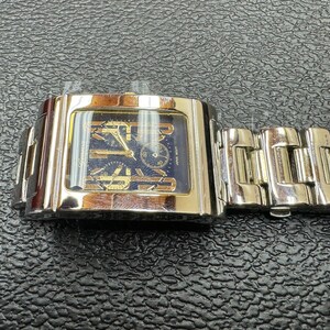 K&ouml;nnte beinhalten: Eine silberne und goldene Herrenarmbanduhr mit quadratischem Zifferblatt und einem Metallband.