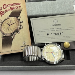 May include: A hybrid mechanical quartz chronograph watch with a cream-colored face, silver case, and black leather band. The watch is displayed in a gray box with a promotional card that reads "First Customizable Retro Watch!!". The watch case size is 40mm.