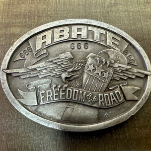 May include: Silver belt buckle with an eagle design and the text "ABATE 666 FREEDOM OF THE ROAD 666".