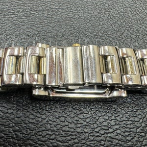 K&ouml;nnte beinhalten: Ein silbernes und goldenes Armband mit einem Verschluss. Das Armband besteht aus Metallgliedern.