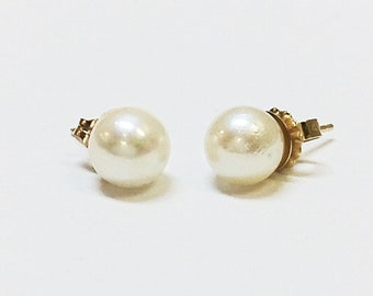 Puede incluir: Un par de pendientes de perlas con engastes de oro. Las perlas son blancas y redondas.
