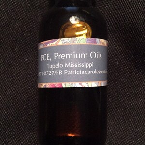 May include: A small, dark brown glass bottle with a black cap. The bottle has a white label with the text "PCE, Premium Oils, Tupelo Mississippi, 671-0727/FB Patriciacarolessentials".