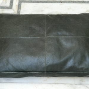 Könnte beinhalten: Ein dunkelgrünes Lederhundebett in rechteckiger Form mit gestepptem Design.