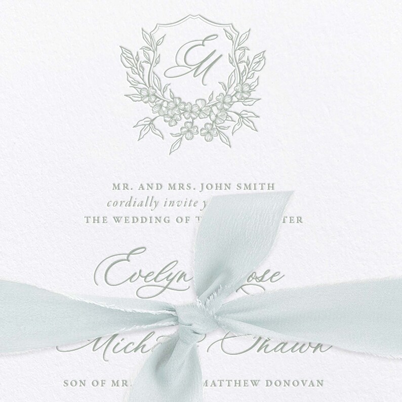 May include: A wedding invitation with a light blue ribbon tied in a bow. The invitation features a floral monogram with the initials "EM" and the text "MR. AND MRS. JOHN SMITH cordially invite you to THE WEDDING OF Evelyn Rose and Michael Shawn SON OF MR. MATTHEW DONOVAN."