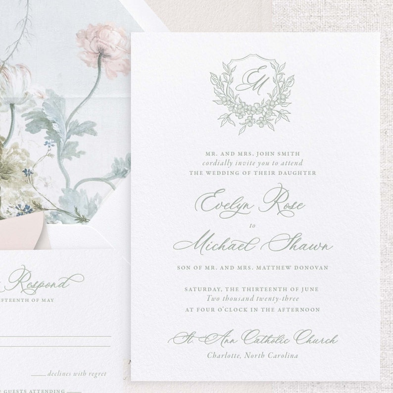 May include: Wedding invitation featuring a green and white floral design. The invitation is for Evelyn Rose and Michael Shawn, and it states the wedding will take place on Saturday, 13th June 2023 at 4:00 PM at St. Ann Catholic Church in Charlotte, North Carolina.