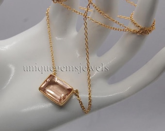 Puede incluir: Un collar de cadena de oro con un colgante rectangular de piedra preciosa rosa claro. El colgante está engastado en un engaste de bisel de oro.