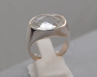 May include: A silver ring with a large, clear, faceted gemstone.