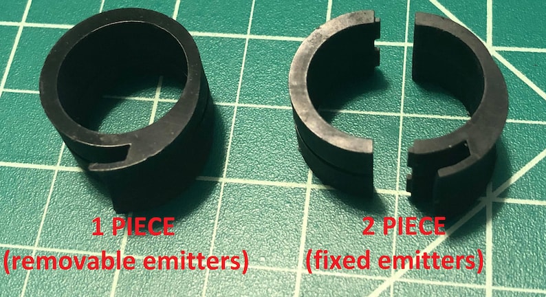 K&ouml;nnte beinhalten: Zwei schwarze Kunststoffringe, einer in einem St&uuml;ck und der andere in zwei Teilen. Der einteilige Ring ist mit "1 TEIL (austauschbare Emitter)" beschriftet und der zweiteilige Ring mit "2 TEILE (feste Emitter)".