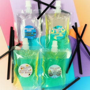 May include: Four clear plastic pouches filled with scented wax for reed diffusers. The pouches are labelled with different scents: "Flight of Passage", "Pineapple Whippy", "Bakery of Main Street", and "The Small World Main Street".