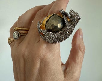 Alexis Bittar Siyabona Panther Ring featuring a crystal-covered panther atop a hammered gold-tone setting with a faceted pyrite center stone