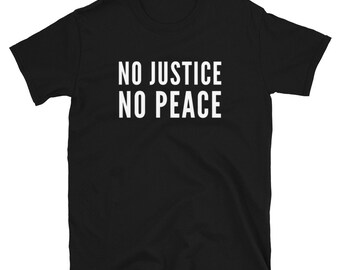 以下が含まれることがあります： 「NO JUSTICE NO PEACE」という白い文字が書かれた黒いTシャツです。