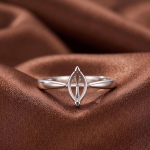 May include: A silver-toned metal ring setting featuring a marquise-shaped basket prong mount designed to hold a gemstone. The band is smooth and tapers toward the center, where the vertical, pointed setting is securely attached to the ring shank.